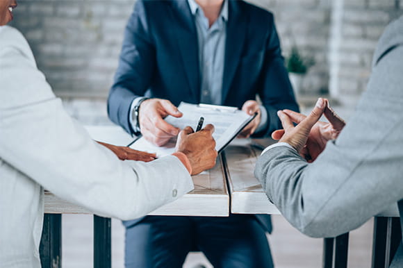 People signing papers at a table