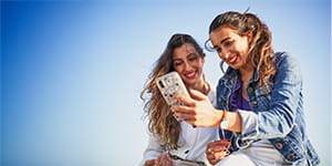 Two women outside on a sunny day taking a selfie