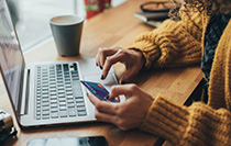 A person entering credit card info onto a laptop