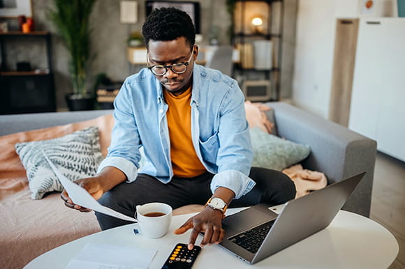 Man looking over finances on devices 