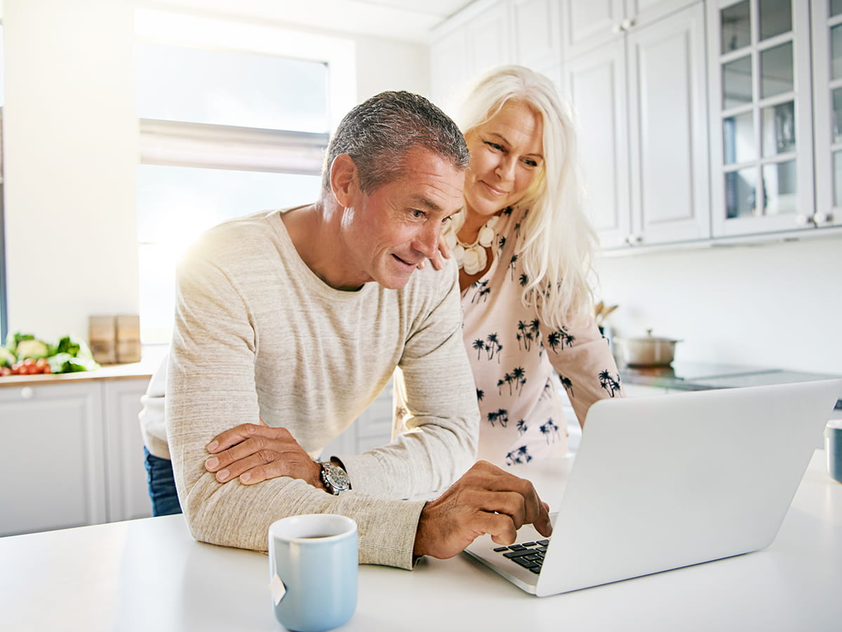 A couple sitting looking at a laptop