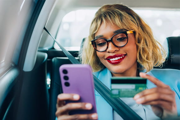 woman looking at phone smiling, avoid credit card interest