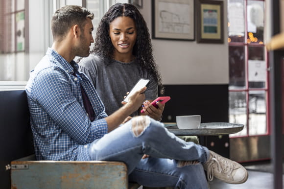 A couple on a couch discussing expenses. Be Prepared for a Financial Emergency.