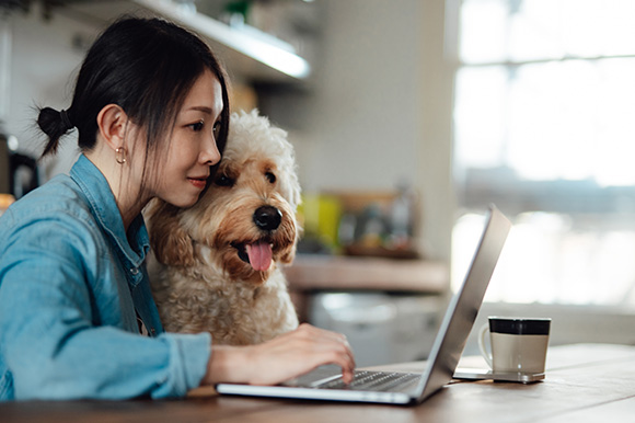 Woman with her dog working on a computer