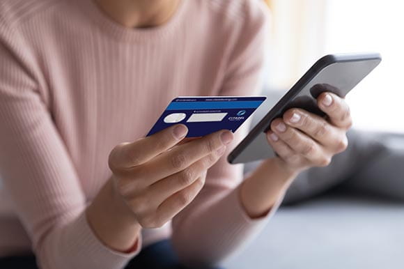 person holding phone and credit card