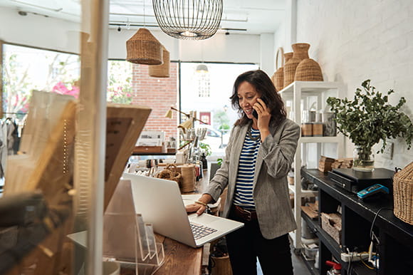 A small business owner working on her laptop in her store